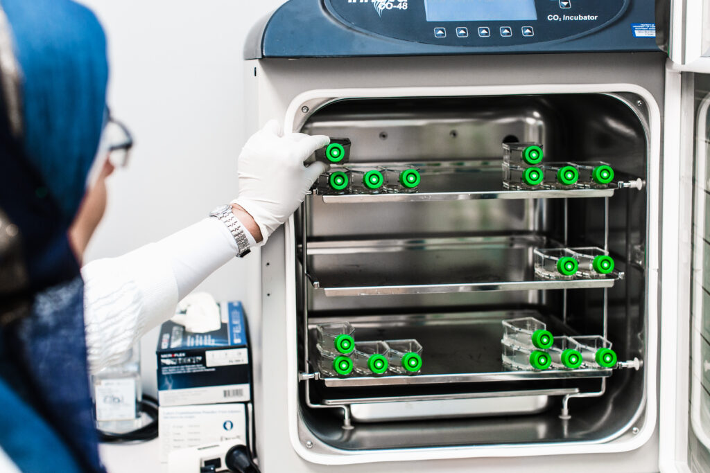 Research lab manager places specimen into an incubator