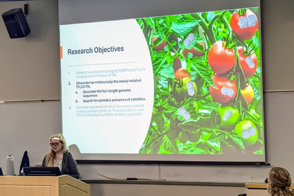 Amanda Penicks standing at a podium presenting research