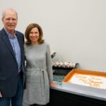 Frank Hale and his wife standing beside a cake.