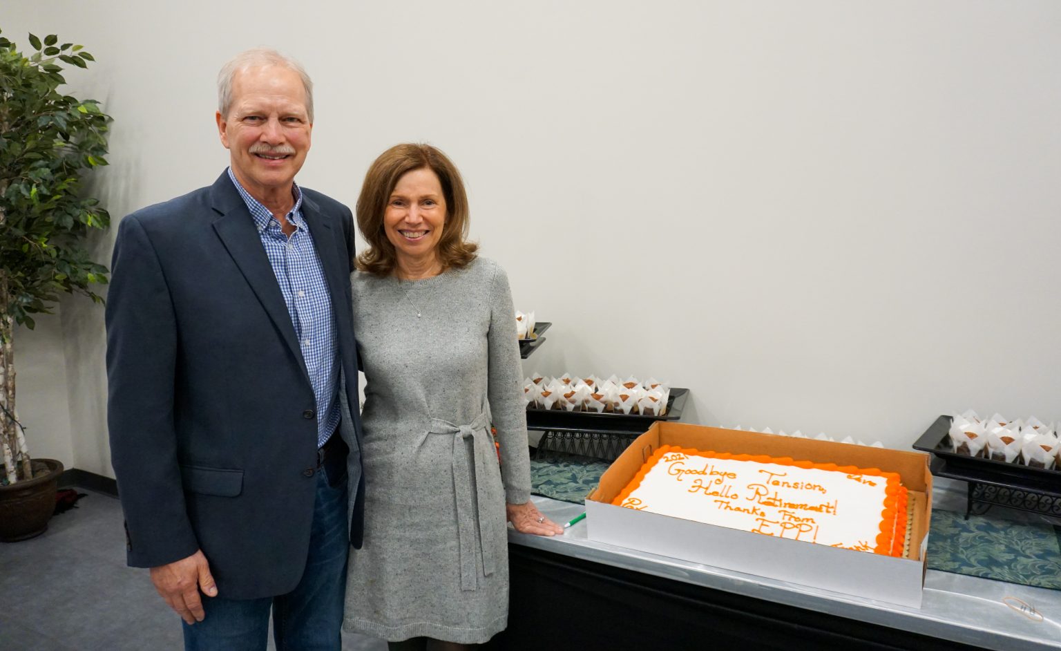 Frank Hale and his wife standing beside a cake.