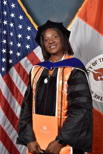 Michelle Odoi snaps a photo in her graduation regalia.